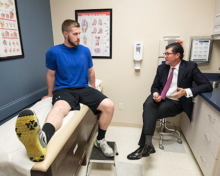 Mike Maloney confers with his patient, former Cornell football offensive lineman Matt Simmonds. (Photo: Jessica Hill/AP Images for Rochester Review)